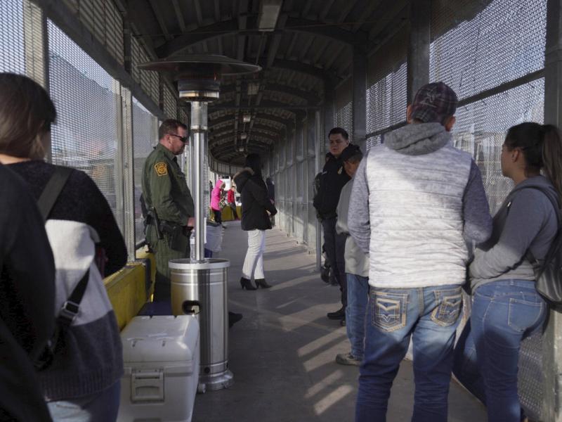 A Border Patrol agent and a U.S. Customs and Border Protection agent oversee the people waiting to cross into the U.S. from Matamoros, Mexico, at the Port of Entry in Brownsville, Tex., Tuesday, last month. A Border Patrol agent and a U.S. Customs and Border Protection agent oversee the people waiting to cross into the U.S. from Matamoros, Mexico, at the Port of Entry in Brownsville, Tex., Tuesday, last month.