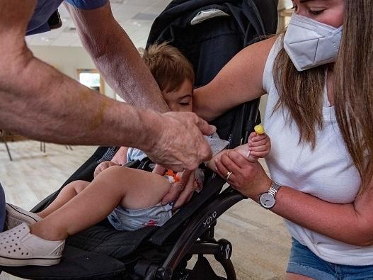 A mother holds her 1-year-old son as he receives the child Covid-19 vaccine in his thigh at Temple Beth Shalom in Needham, Mass., on June 21, 2022. The temple was one of the first sites in the state to offer vaccinations to anyone in the public. A mother holds her 1-year-old son as he receives the child Covid-19 vaccine in his thigh at Temple Beth Shalom in Needham, Mass., on June 21, 2022. The temple was one of the first sites in the state to offer vaccinations to anyone in the public.