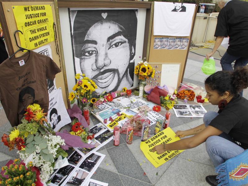 A woman leaves a sign at a street-side memorial to shooting victim Oscar Grant in Oakland, Calif., in 2010. A Northern California prosecutor announced Monday that she will reopen the investigation into the killing of Grant at a train station by a police o A woman leaves a sign at a street-side memorial to shooting victim Oscar Grant in Oakland, Calif., in 2010. A Northern California prosecutor announced Monday that she will reopen the investigation into the killing of Grant at a train station by a police o