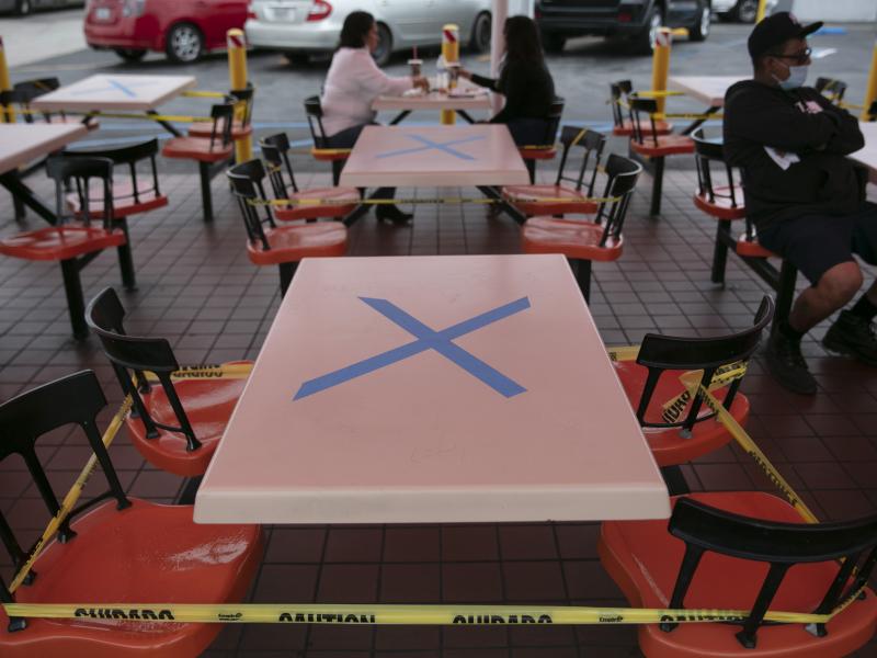 Tables are marked with X's for social distancing in the outdoor dining area of a restaurant in Los Angeles, Wednesday. California Gov. Gavin Newsom has ordered a three-week closure of bars and indoor operations of restaurants and certain other businesses Tables are marked with X's for social distancing in the outdoor dining area of a restaurant in Los Angeles, Wednesday. California Gov. Gavin Newsom has ordered a three-week closure of bars and indoor operations of restaurants and certain other businesses