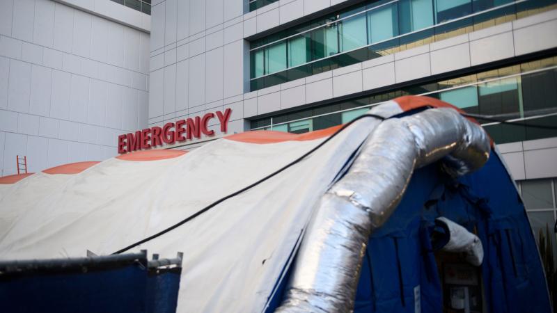 A field hospital tent stands outside the emergency department of the Martin Luther King Jr. Community Hospital earlier this month in Los Angeles. California is returning to a tiered restriction system. A field hospital tent stands outside the emergency department of the Martin Luther King Jr. Community Hospital earlier this month in Los Angeles. California is returning to a tiered restriction system.