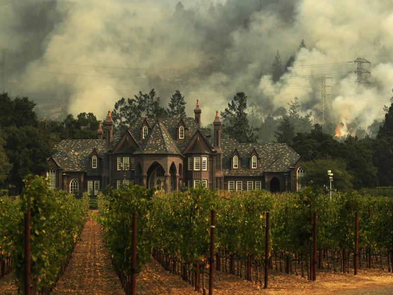 The Tubbs wildfire burns behind a winery in Santa Rosa, Calif., in 2017. A state report finds that it was caused by privately owned utility lines. The Tubbs wildfire burns behind a winery in Santa Rosa, Calif., in 2017. A state report finds that it was caused by privately owned utility lines.