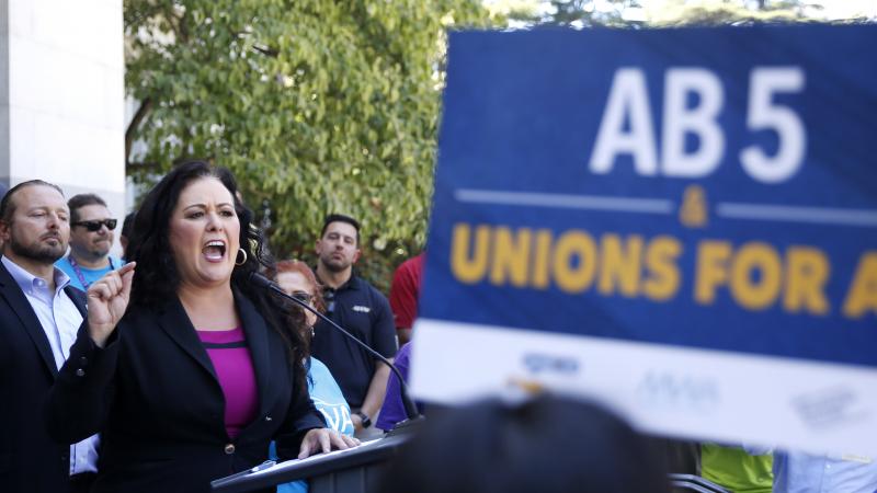 Democratic Assemblywoman Lorena Gonzalez speaks at a July rally for independent contractors in Sacramento, Calif. The measure that passed Tuesday in the state Senate requires companies such as Lyft and Uber to turn many contract workers into employees. Democratic Assemblywoman Lorena Gonzalez speaks at a July rally for independent contractors in Sacramento, Calif. The measure that passed Tuesday in the state Senate requires companies such as Lyft and Uber to turn many contract workers into employees.