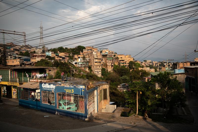 A man cleans a rooftop as the sun sets over the embattled Pedregal neighborhood of Tegucigalpa. A man cleans a rooftop as the sun sets over the embattled Pedregal neighborhood of Tegucigalpa.