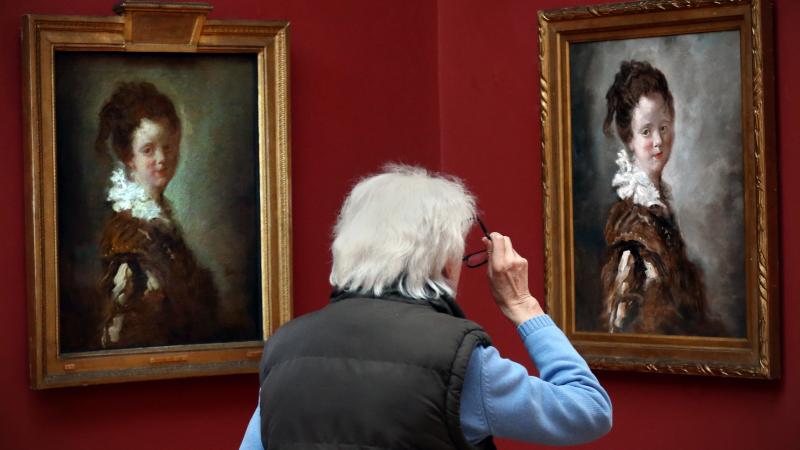 A visitor views a replica of Jean-Honore Fragonard's 18th century painting, Young Woman (right) as the original hangs to its left. A visitor views a replica of Jean-Honore Fragonard's 18th century painting, Young Woman (right) as the original hangs to its left.