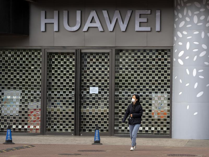 A woman wearing a face mask walks past a Huawei store temporarily closed due to coronavirus-related restrictions in Beijing, Thursday, May 12, 2022. China's leaders are struggling to reverse a deepening economic slump while keeping a "zero-COVID" strategy A woman wearing a face mask walks past a Huawei store temporarily closed due to coronavirus-related restrictions in Beijing, Thursday, May 12, 2022. China's leaders are struggling to reverse a deepening economic slump while keeping a "zero-COVID" strategy