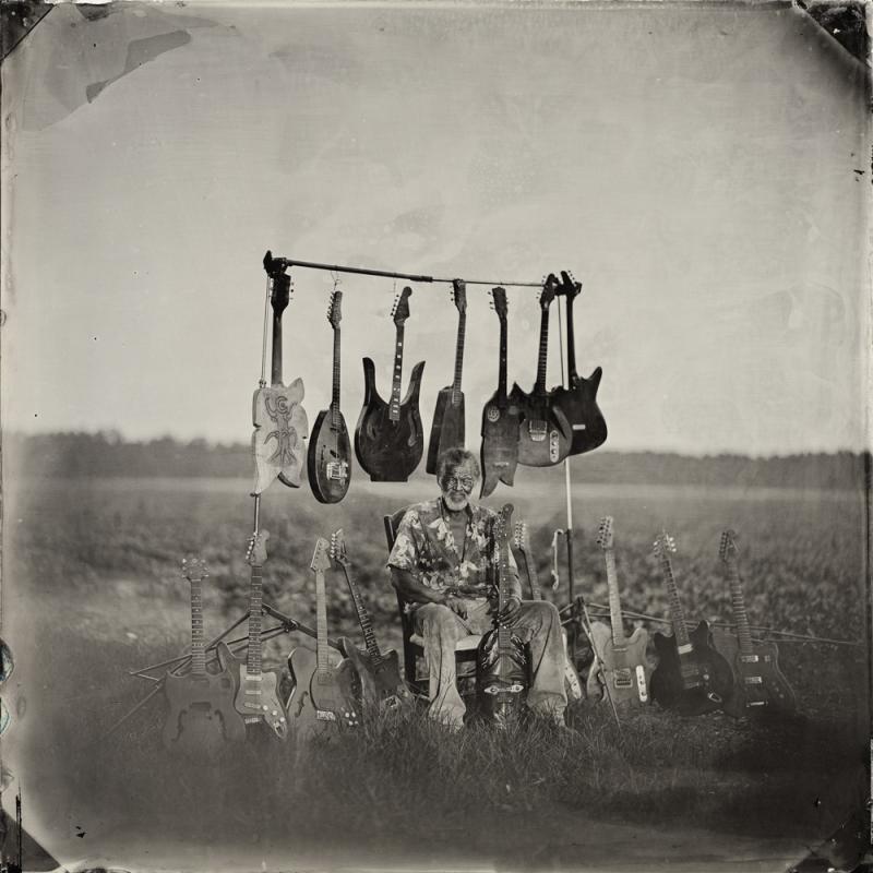 Luthier Freeman Vines sits with his hand-carved guitars in the tobacco field by his house, 2015. Luthier Freeman Vines sits with his hand-carved guitars in the tobacco field by his house, 2015.