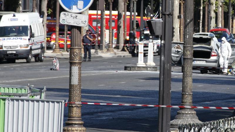 Police search a white car (right) that had been rammed into a police van on the Champs-Élysées in Paris on Monday afternoon. Police search a white car (right) that had been rammed into a police van on the Champs-Élysées in Paris on Monday afternoon.