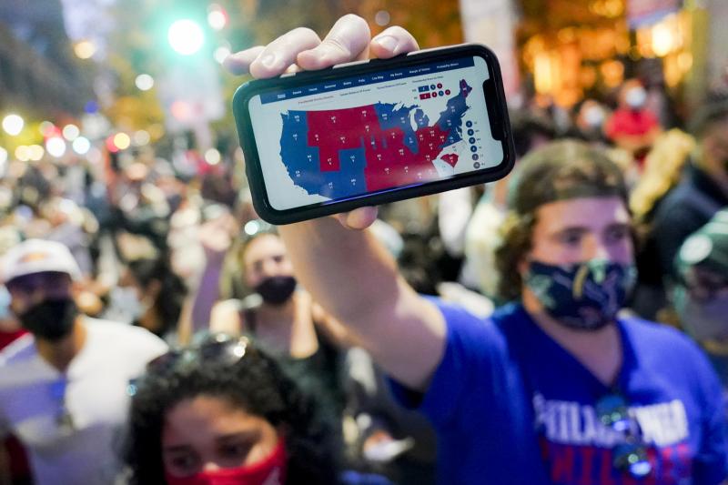 A Joe Biden supporter holds up a phone displaying the Electoral College map in Philadelphia on Nov. 7. A Joe Biden supporter holds up a phone displaying the Electoral College map in Philadelphia on Nov. 7.