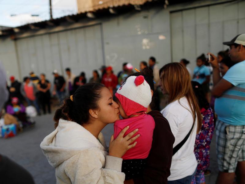 A member of a migrant caravan from Central America kisses a baby as they pray in preparation for an asylum request in the U.S., in Tijuana, Baja California state, Mexico. A member of a migrant caravan from Central America kisses a baby as they pray in preparation for an asylum request in the U.S., in Tijuana, Baja California state, Mexico.