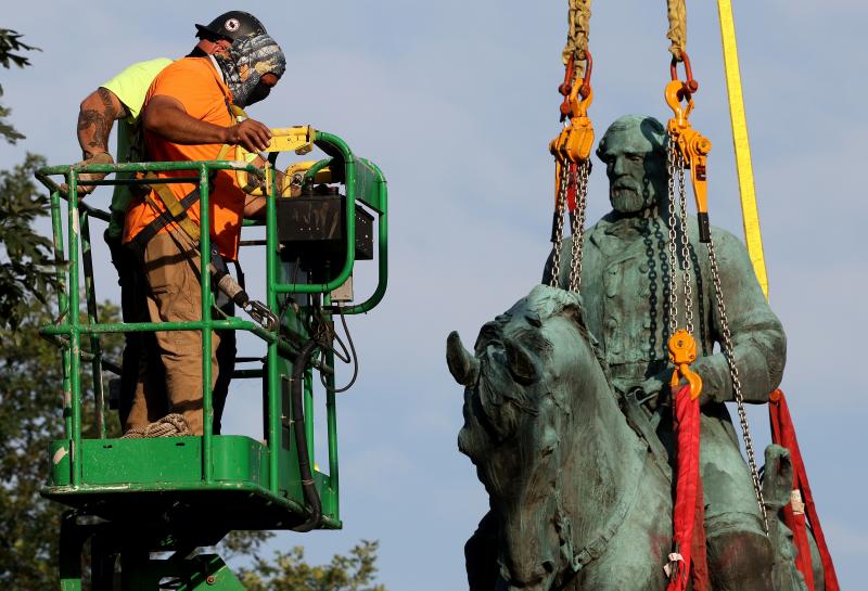 Workers remove a statue of Confederate Gen. Robert E. Lee from Market Street Park on Saturday in Charlottesville, Va. Workers remove a statue of Confederate Gen. Robert E. Lee from Market Street Park on Saturday in Charlottesville, Va.