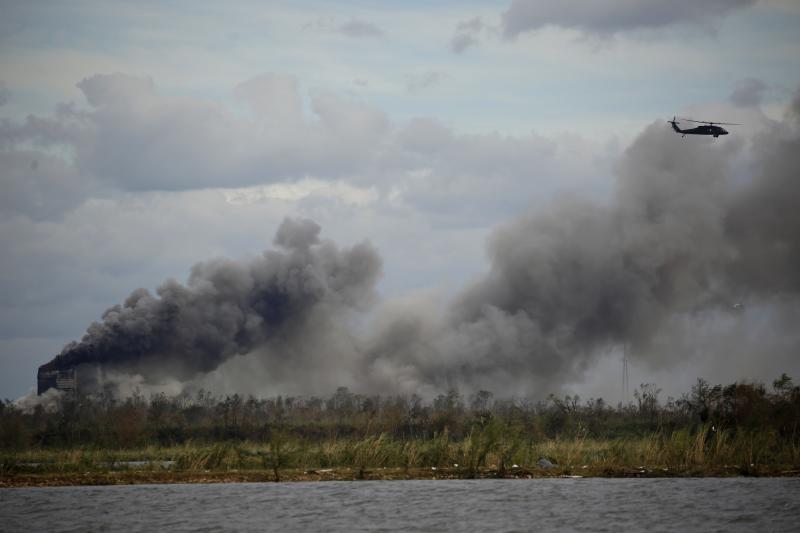 A helicopter flies over a chemical fire at BioLab plant after Hurricane Laura made landfall in Westlake, La., on Aug. 27, 2020. A helicopter flies over a chemical fire at BioLab plant after Hurricane Laura made landfall in Westlake, La., on Aug. 27, 2020.