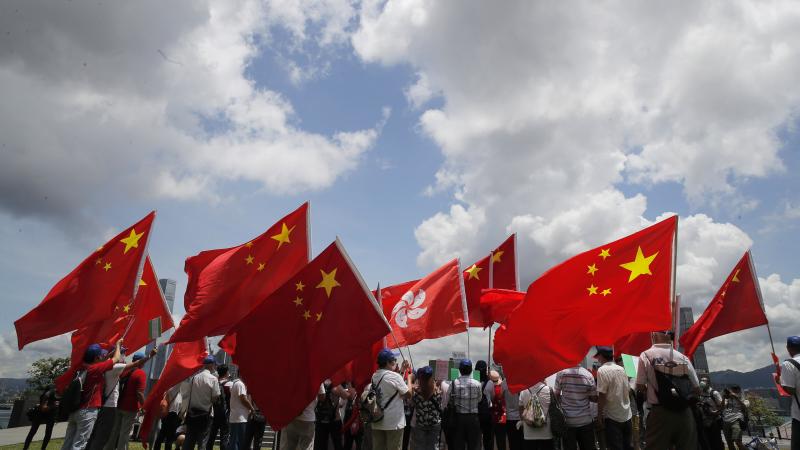 Pro-mainland supporters in Hong Kong hold Chinese and Hong Kong flags during a rally to celebrate the approval of a national security law on Tuesday. Pro-mainland supporters in Hong Kong hold Chinese and Hong Kong flags during a rally to celebrate the approval of a national security law on Tuesday.