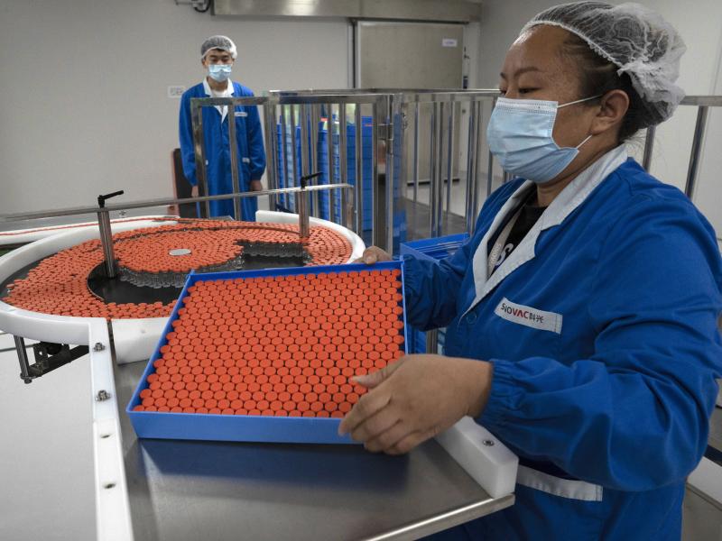 A worker feeds vials for production of a vaccine for COVID-19 at the SinoVac vaccine factory in Beijing. China said on Friday that it is joining the COVID-19 vaccine alliance known as COVAX. A worker feeds vials for production of a vaccine for COVID-19 at the SinoVac vaccine factory in Beijing. China said on Friday that it is joining the COVID-19 vaccine alliance known as COVAX.