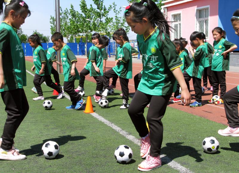 First-graders take soccer class at the Nandulehe Elementary School in suburban Beijing. The school is one of 20,000 that's launching a national soccer curriculum in the next five years. It's part of a government plan to raise China's soccer skills and eve First-graders take soccer class at the Nandulehe Elementary School in suburban Beijing. The school is one of 20,000 that's launching a national soccer curriculum in the next five years. It's part of a government plan to raise China's soccer skills and eve