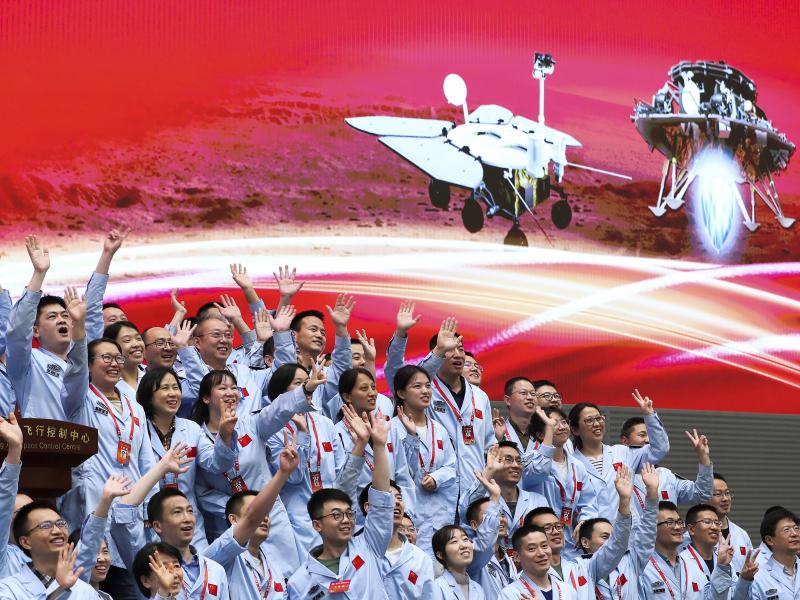 In this photo released by Xinhua News Agency, members at the Beijing Aerospace Control Center celebrate after China's Tianwen-1 probe successfully landed on Mars, at the center in Beijing on Saturday. In this photo released by Xinhua News Agency, members at the Beijing Aerospace Control Center celebrate after China's Tianwen-1 probe successfully landed on Mars, at the center in Beijing on Saturday.