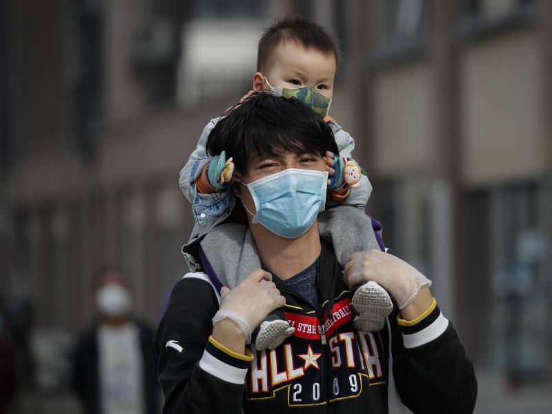 A man carries a toddler on his shoulders on a street in Beijing on Wednesday. While China said it had no new domestic coronavirus cases on Thursday, it reported that dozens more had arrived from abroad. A man carries a toddler on his shoulders on a street in Beijing on Wednesday. While China said it had no new domestic coronavirus cases on Thursday, it reported that dozens more had arrived from abroad.