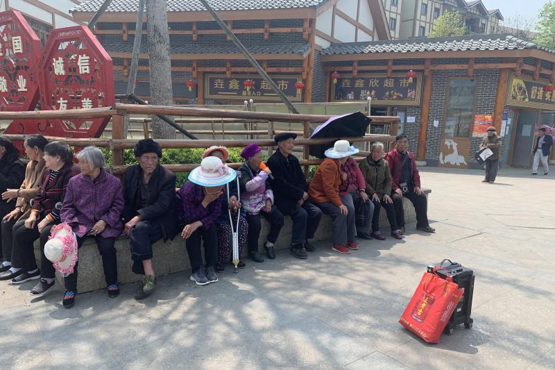 Resettled villagers sun themselves outside Qixingguan. Many older residents have had a difficult time adjusting to life away from their fields. Resettled villagers sun themselves outside Qixingguan. Many older residents have had a difficult time adjusting to life away from their fields.