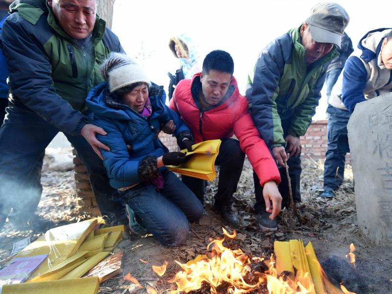 Shang Aiyun (second left) and Li Sanren (second right) mourn at the grave of their son, Huugjilt, in Hohhot, China. Huugjilt was executed in 1996 for the rape and murder of a woman in a public toilet. He was cleared of the crime on Monday. Shang Aiyun (second left) and Li Sanren (second right) mourn at the grave of their son, Huugjilt, in Hohhot, China. Huugjilt was executed in 1996 for the rape and murder of a woman in a public toilet. He was cleared of the crime on Monday.