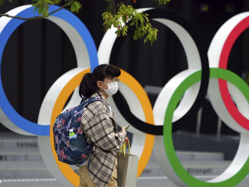 A woman wearing a protective mask to help curb the spread of the coronavirus walks in front of he Olympic Rings on Tuesday in Tokyo. North Korea says it will not attend the games over COVID-19 fears. A woman wearing a protective mask to help curb the spread of the coronavirus walks in front of he Olympic Rings on Tuesday in Tokyo. North Korea says it will not attend the games over COVID-19 fears.