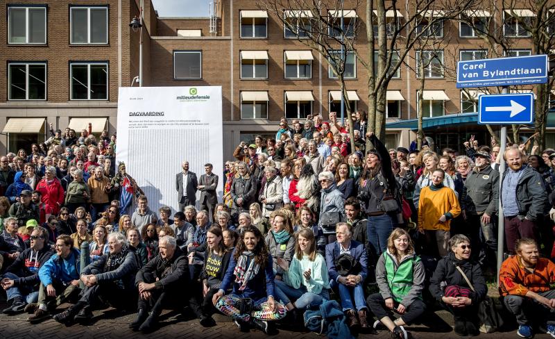 Activists march to Shell's headquarters in The Hague, Netherlands, in April 2019, delivering a legal summons to the company. The civil case began Tuesday, with plaintiffs demanding the company reduce its carbon dioxide emissions. Activists march to Shell's headquarters in The Hague, Netherlands, in April 2019, delivering a legal summons to the company. The civil case began Tuesday, with plaintiffs demanding the company reduce its carbon dioxide emissions.