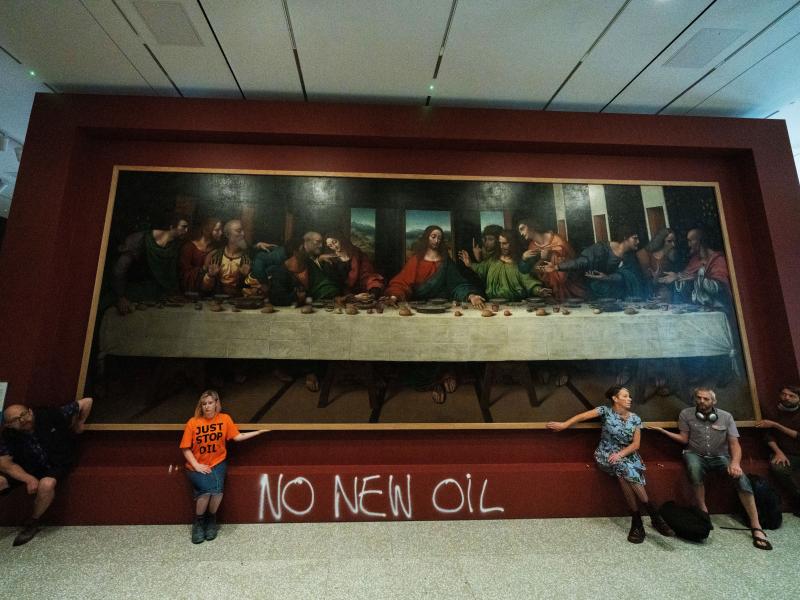 Five Just Stop Oil activists spray paint the wall and glue themselves to the frame of the painting The Last Supper on Tuesday at the Royal Academy in London. Five Just Stop Oil activists spray paint the wall and glue themselves to the frame of the painting The Last Supper on Tuesday at the Royal Academy in London.