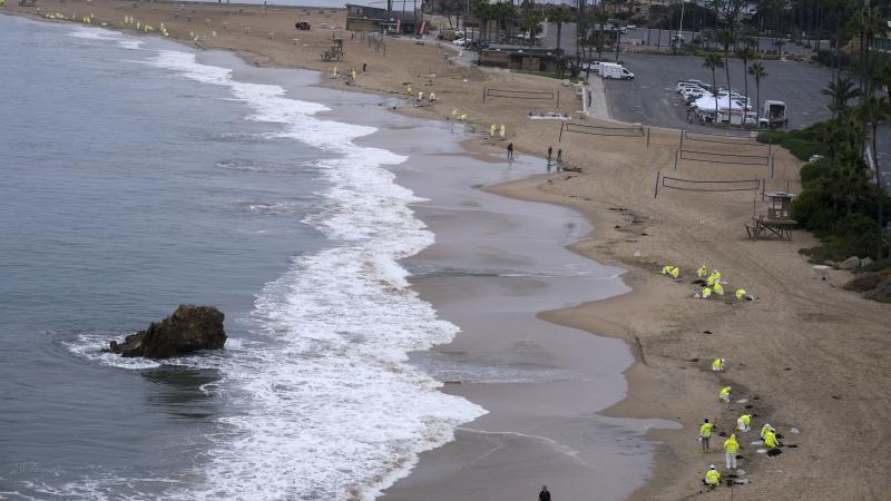 Workers in protective suits clean the contaminated beach in Corona Del Mar on Oct. 7 after an oil spill in Newport Beach, Calif. Workers in protective suits clean the contaminated beach in Corona Del Mar on Oct. 7 after an oil spill in Newport Beach, Calif.