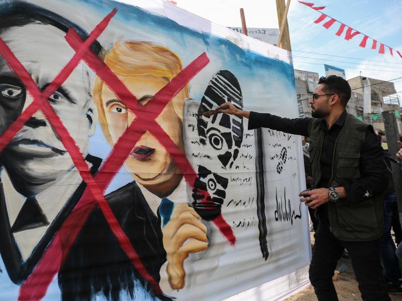A Palestinian paints a picture showing President Trump and the sole of a shoe in the Gaza Strip on Wednesday. A Palestinian paints a picture showing President Trump and the sole of a shoe in the Gaza Strip on Wednesday.