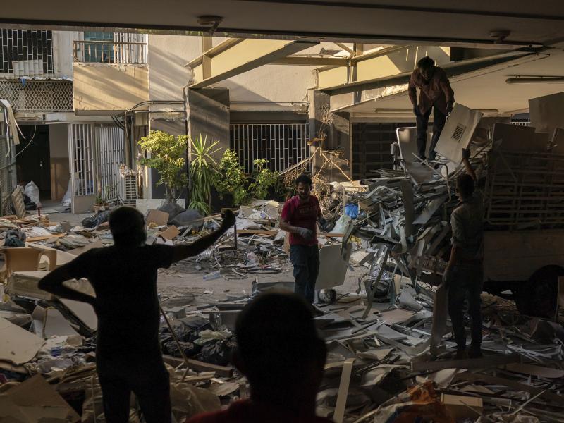 Workers remove debris from a hospital that was heavily damaged in last week's explosion that hit the seaport of Beirut. Workers remove debris from a hospital that was heavily damaged in last week's explosion that hit the seaport of Beirut.