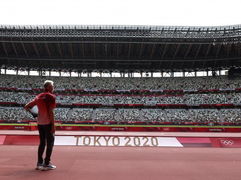A passerby looks on while wearing a protective face covering inside an empty Olympic Stadium, host to the Athletics competition, at the Tokyo Olympic Games on Thursday. A passerby looks on while wearing a protective face covering inside an empty Olympic Stadium, host to the Athletics competition, at the Tokyo Olympic Games on Thursday.