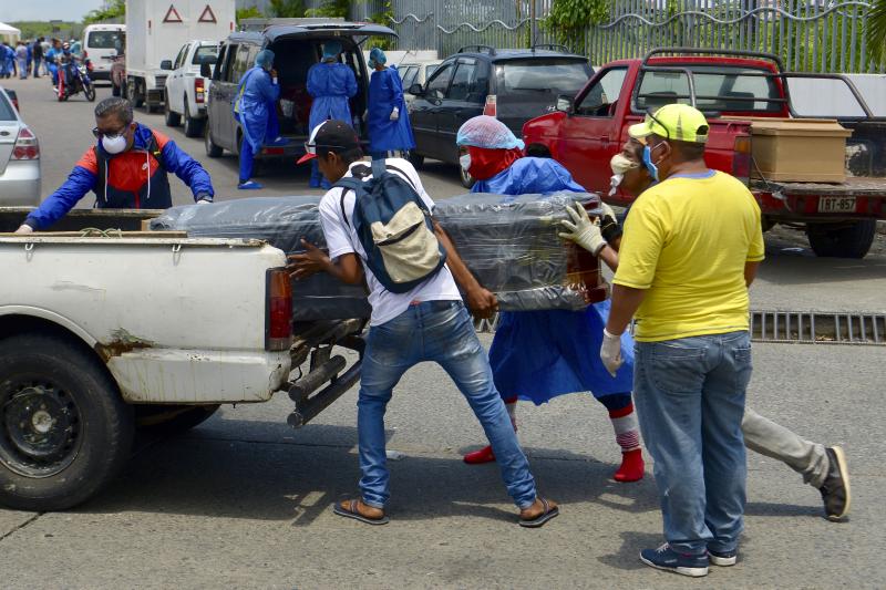 Men load a coffin onto a pickup truck in front of General del Guasmo Sur Hospital in Guayaquil, Ecuador. The port city is the most affected by COVID-19 in the country. Corpses lie in apartments for days and morgues are overcrowded. The city administration Men load a coffin onto a pickup truck in front of General del Guasmo Sur Hospital in Guayaquil, Ecuador. The port city is the most affected by COVID-19 in the country. Corpses lie in apartments for days and morgues are overcrowded. The city administration