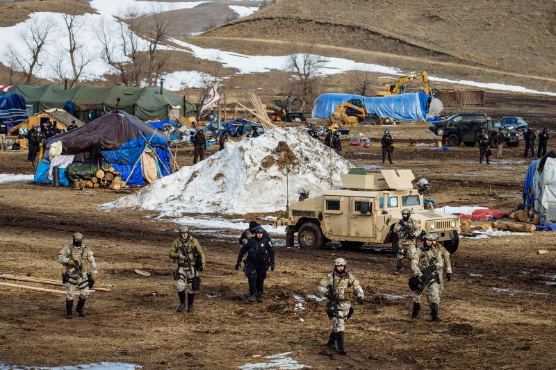 Police move through the camp of protesters against the Dakota Access Pipeline near Cannon Ball, N.D., in February. Despite months of protests by Native American tribes and environmental groups, crude oil is now flowing through the pipeline. Police move through the camp of protesters against the Dakota Access Pipeline near Cannon Ball, N.D., in February. Despite months of protests by Native American tribes and environmental groups, crude oil is now flowing through the pipeline.