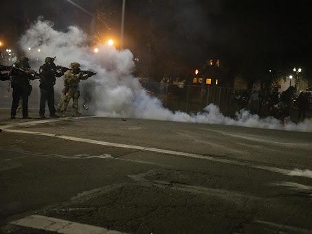 Federal law enforcement officers fire impact munitions and tear gas at protesters demonstrating against racism and police violence in front of the Mark O. Hatfield federal courthouse in Portland, Ore., on July 16, 2020. Through the end of 2020, the majori Federal law enforcement officers fire impact munitions and tear gas at protesters demonstrating against racism and police violence in front of the Mark O. Hatfield federal courthouse in Portland, Ore., on July 16, 2020. Through the end of 2020, the majori