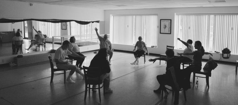 Christina Soriano (seated far right with both arms outstretched) leads her IMPROVment dance class warm ups. IMPROVment dance class in session.
