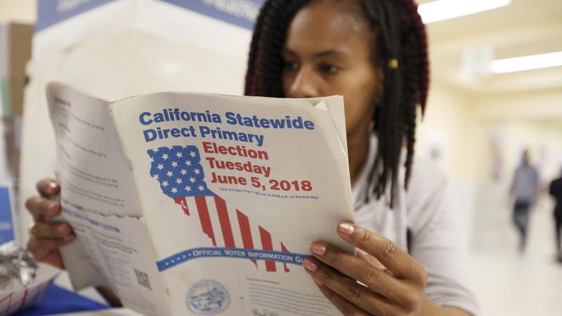 Nikko Johnson reviews the California Primary election guide at San Francisco City Hall on Tuesday. Nikko Johnson reviews the California Primary election guide at San Francisco City Hall on Tuesday.