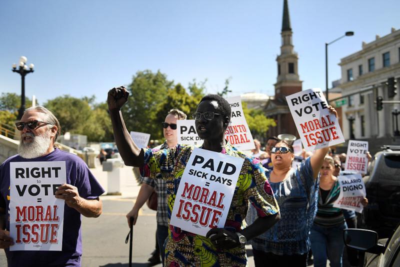 Robert Odeki (center) marches with SEIU Local 105 as the union protested for a minimum wage of $15 an hour outside the Colorado State Capitol in September. Robert Odeki (center) marches with SEIU Local 105 as the union protested for a minimum wage of $15 an hour outside the Colorado State Capitol in September.