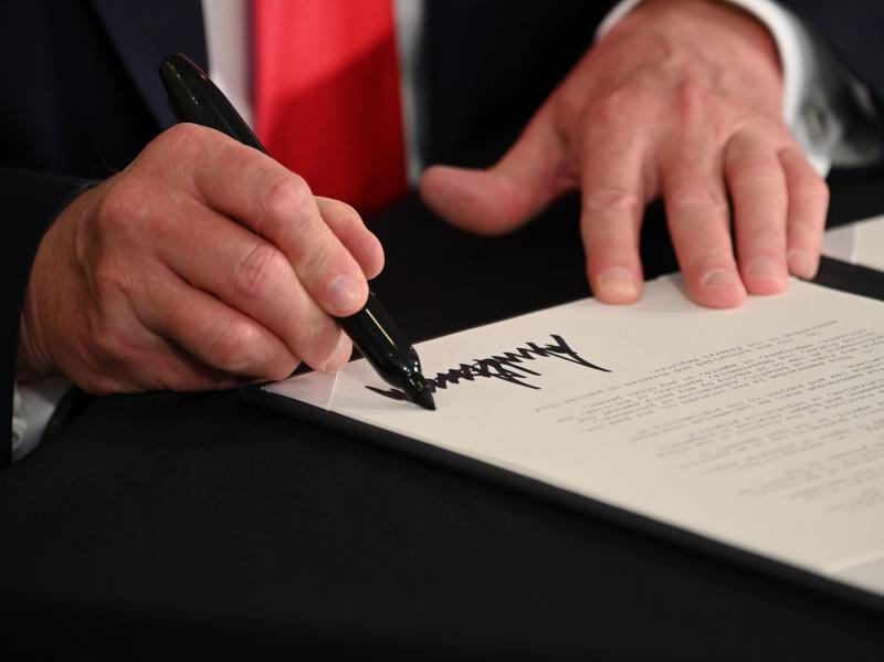 President Trump signs executive actions regarding coronavirus economic relief during a news conference in Bedminster, N.J., on Saturday. A number of lawmakers are criticizing the measures' substance and constitutionality. President Trump signs executive actions regarding coronavirus economic relief during a news conference in Bedminster, N.J., on Saturday. A number of lawmakers are criticizing the measures' substance and constitutionality.