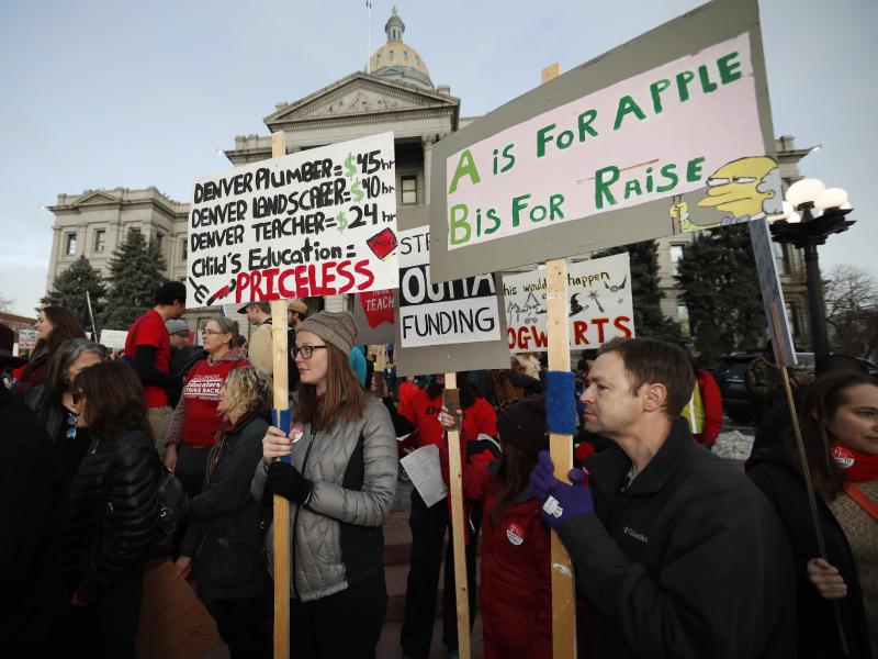 Denver teachers carry placards as they wait to march after a rally in support of a strike outside the state Capitol last month. Denver schoolteachers are going on strike over how their base pay is calculated. Denver teachers carry placards as they wait to march after a rally in support of a strike outside the state Capitol last month. Denver schoolteachers are going on strike over how their base pay is calculated.