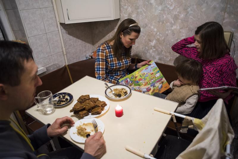 Marina Kluchnikov reads to her youngest child, Sasha, 3, as husband Artyom Kluchnikov looks on and daughter Olenka, 11, reads a book of her own. With Russian troops amassed along Ukraine's border, they worry if an invasion could be imminent. Marina Kluchnikov reads to her youngest child, Sasha, 3, as husband Artyom Kluchnikov looks on and daughter Olenka, 11, reads a book of her own. With Russian troops amassed along Ukraine's border, they worry if an invasion could be imminent.