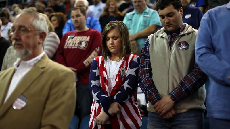 Donald Trump supporters pray while waiting to hear him speak at a campaign event in Mississippi. Donald Trump supporters pray while waiting to hear him speak at a campaign event in Mississippi.