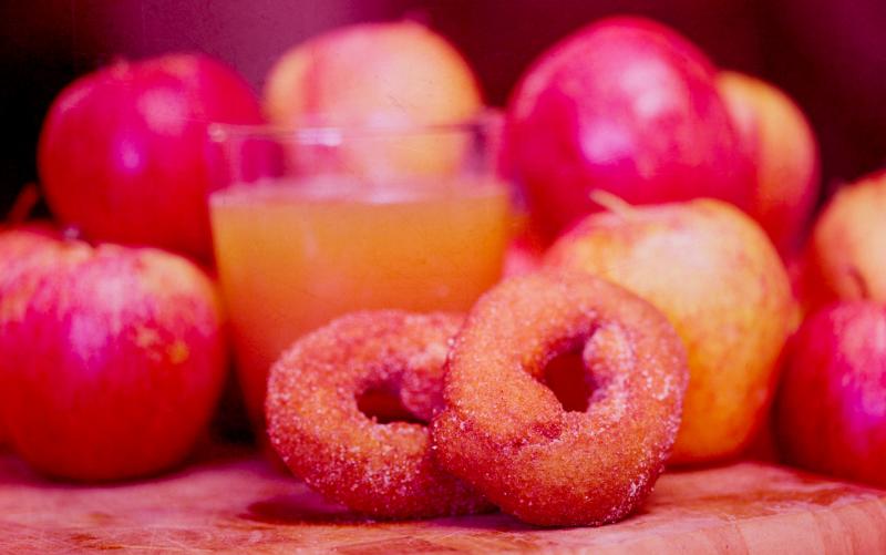 A cold, crisp glass of apple cider helps wash down those deliciously oily donuts, still hot from the fryer. A cold, crisp glass of apple cider helps wash down those deliciously oily donuts, still hot from the fryer.