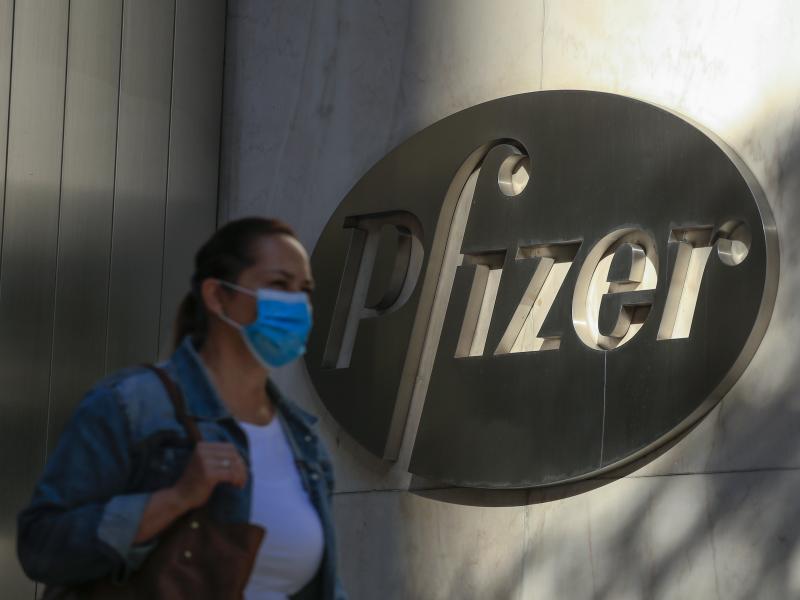 A woman wears a mask as she walks by Pfizer's world headquarters in New York last month. A woman wears a mask as she walks by Pfizer's world headquarters in New York last month.