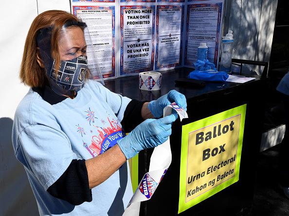 Volunteer Esmeralda Raymond gets a roll of "I Voted" stickers ready at a polling site in Las Vegas on the first day of in-person early voting on Oct. 17. Volunteer Esmeralda Raymond gets a roll of "I Voted" stickers ready at a polling site in Las Vegas on the first day of in-person early voting on Oct. 17.