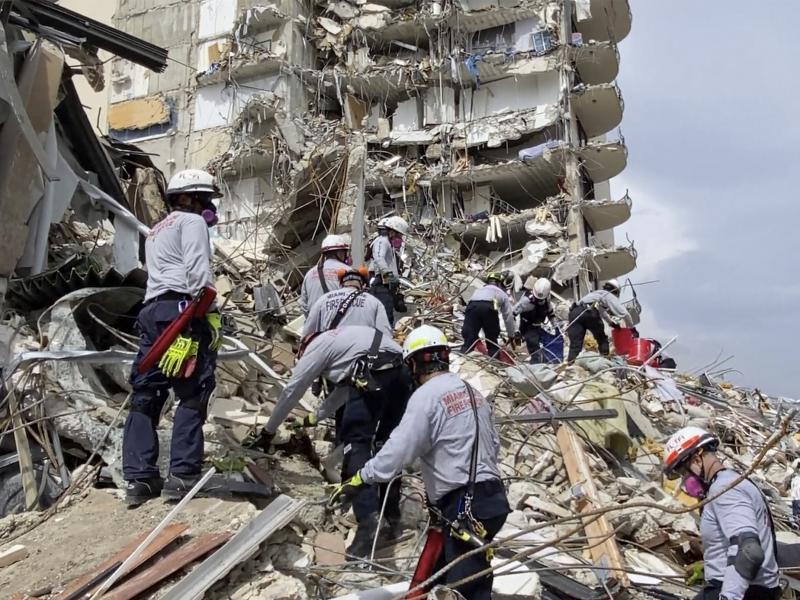 In this photo provided by Miami-Dade Fire Rescue, search-and-rescue personnel search for survivors through the rubble at the Champlain Towers South Condo in Surfside, Fla., on Friday. In this photo provided by Miami-Dade Fire Rescue, search-and-rescue personnel search for survivors through the rubble at the Champlain Towers South Condo in Surfside, Fla., on Friday.