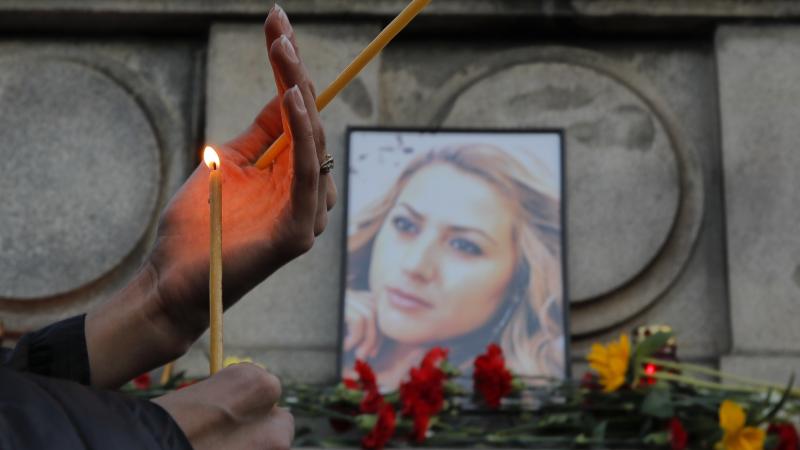 A woman holds a candle next to a portrait of slain journalist Viktoria Marinova during a vigil at the Monument of Liberty in Ruse, Bulgaria, on Monday. A woman holds a candle next to a portrait of slain journalist Viktoria Marinova during a vigil at the Monument of Liberty in Ruse, Bulgaria, on Monday.