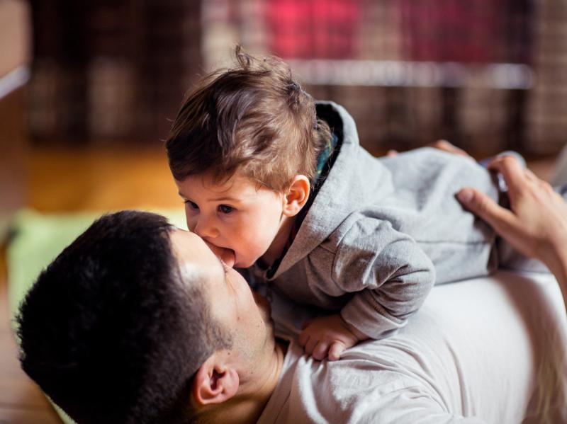 This stock image shows a baby and father playing at home. New research finds that babies judge the relationship between two people by whether or not they willingly share saliva. This stock image shows a baby and father playing at home. New research finds that babies judge the relationship between two people by whether or not they willingly share saliva.
