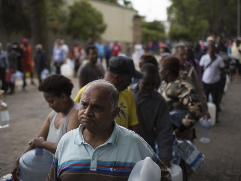 Residents wait to fill containers at a source for natural spring water in Cape Town, South Africa. Residents wait to fill containers at a source for natural spring water in Cape Town, South Africa.