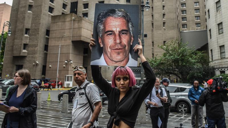 A member of the protest group Hot Mess holds up a sign of Jeffrey Epstein in front of the Metropolitan Correctional Center in New York City in July 2019. Epstein died by asphyxiation in his cell a month later. A member of the protest group Hot Mess holds up a sign of Jeffrey Epstein in front of the Metropolitan Correctional Center in New York City in July 2019. Epstein died by asphyxiation in his cell a month later.