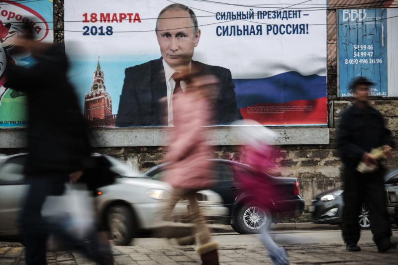 Pedestrians pass by a billboard with an image of Russia's President Vladimir Putin and lettering "Strong president - Strong Russia!" in Simferopol, Crimea in January. Pedestrians pass by a billboard with an image of Russia's President Vladimir Putin and lettering "Strong president - Strong Russia!" in Simferopol, Crimea in January.