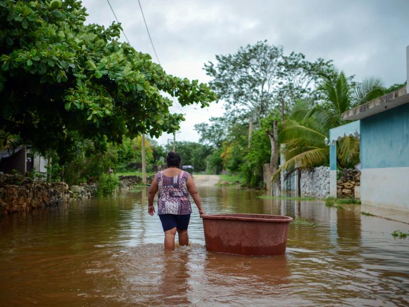 A woman from the Mayan community of Tecoh wades through the water in a flood caused by Tropical Storm Cristobal in the town of Tecoh, near Merida in Yucatan State, Mexico, in June 2020. A woman from the Mayan community of Tecoh wades through the water in a flood caused by Tropical Storm Cristobal in the town of Tecoh, near Merida in Yucatan State, Mexico, in June 2020.